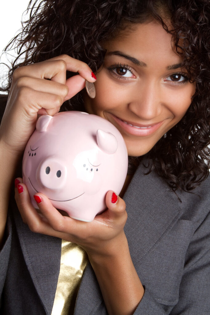 Woman dropping money into piggy bank.